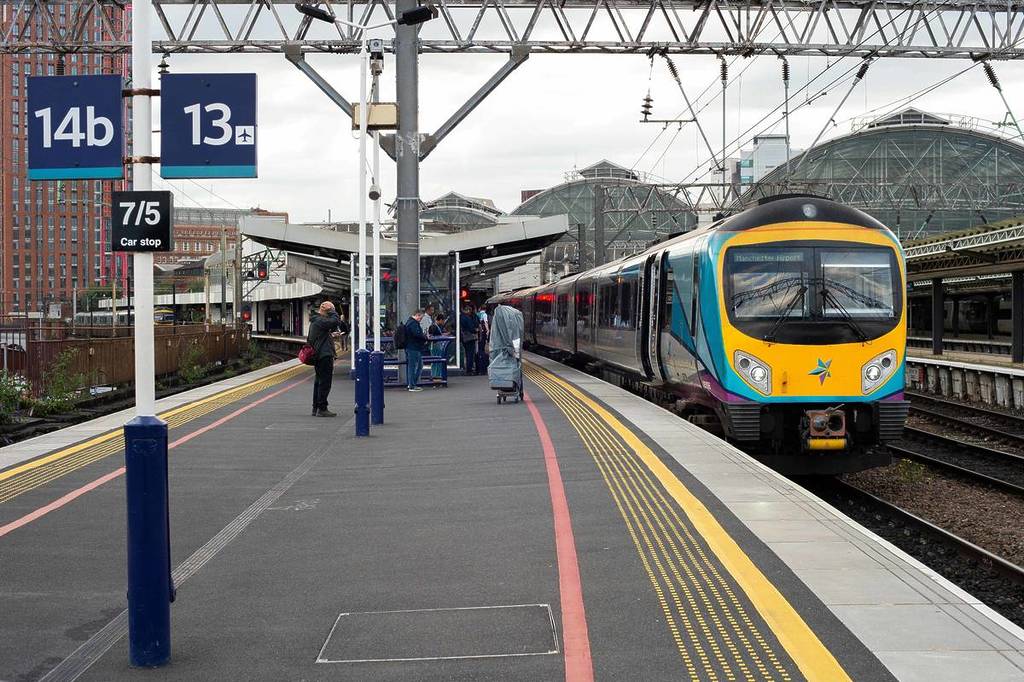 transpennine express train coming into platform 14 and 13 at manchester piccadilly station
