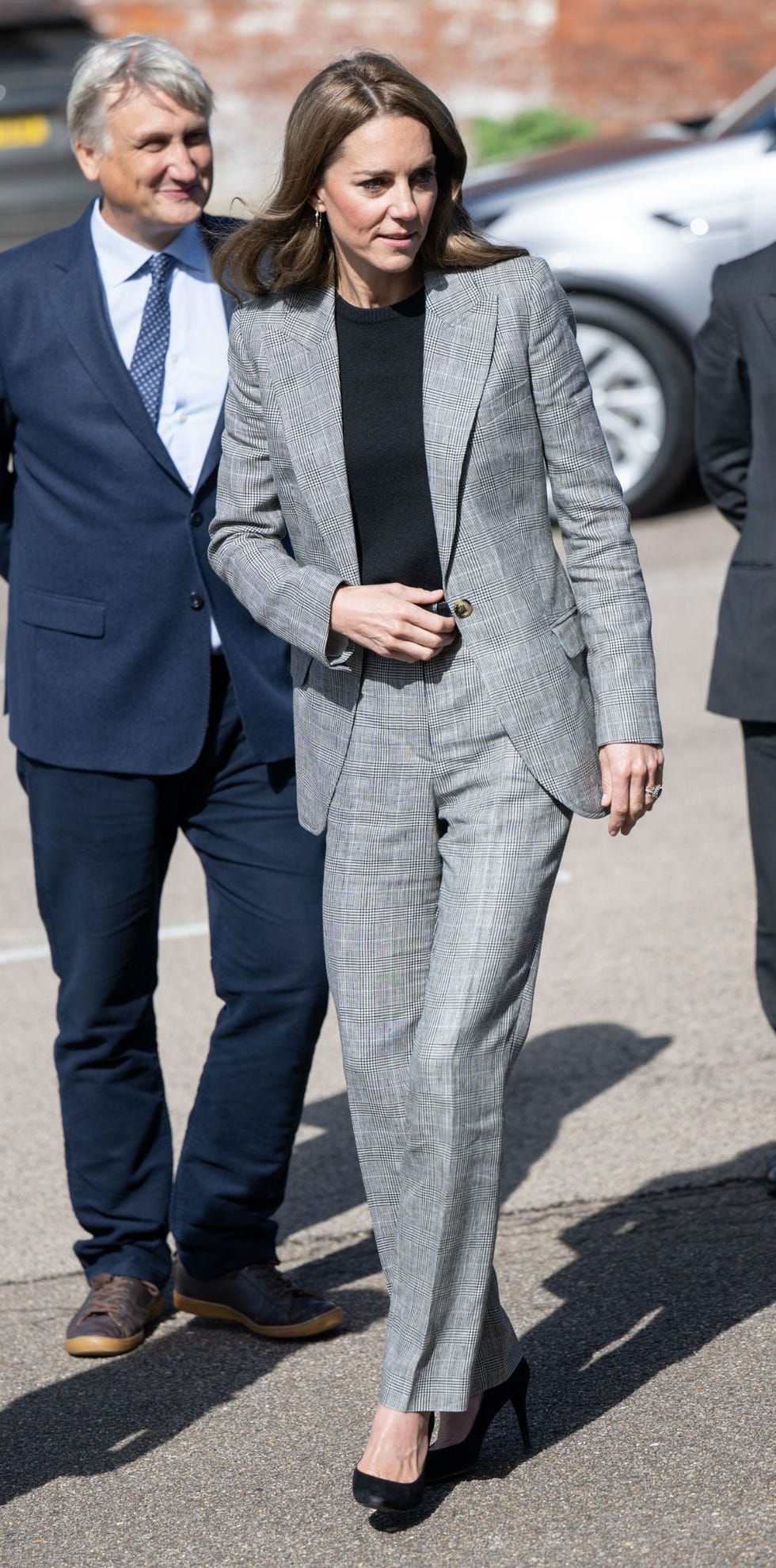 a formal outfit worn by a woman walking alongside a man