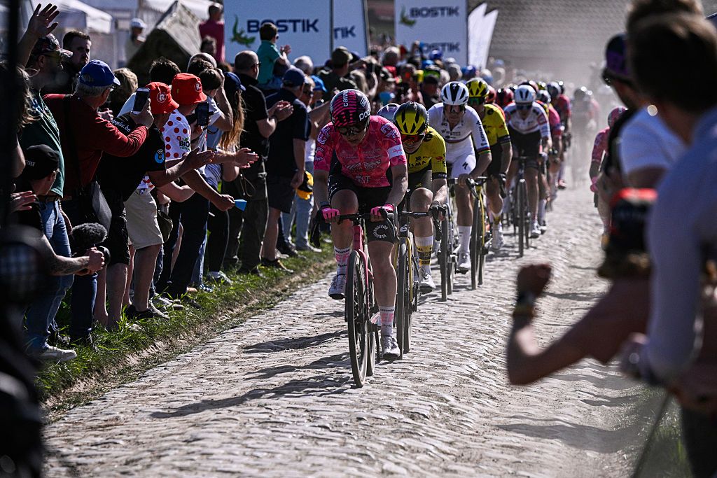 The pack of riders cycles on pavement during the fifth edition of the Paris-Roubaix women's race, 148,5 km between Denain and Roubaix, northern France on April 12, 2025. (Photo by JULIEN DE ROSA / AFP)