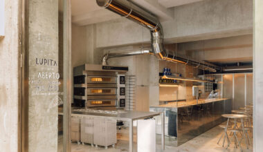 reflective steel interiors bring lisbon’s street activity into pizza restaurant