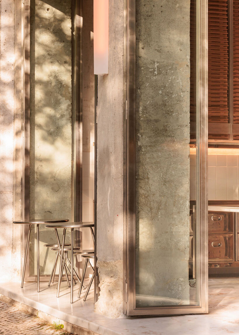 reflective steel interiors and open facade bring lisbon’s street activity into pizza restaurant