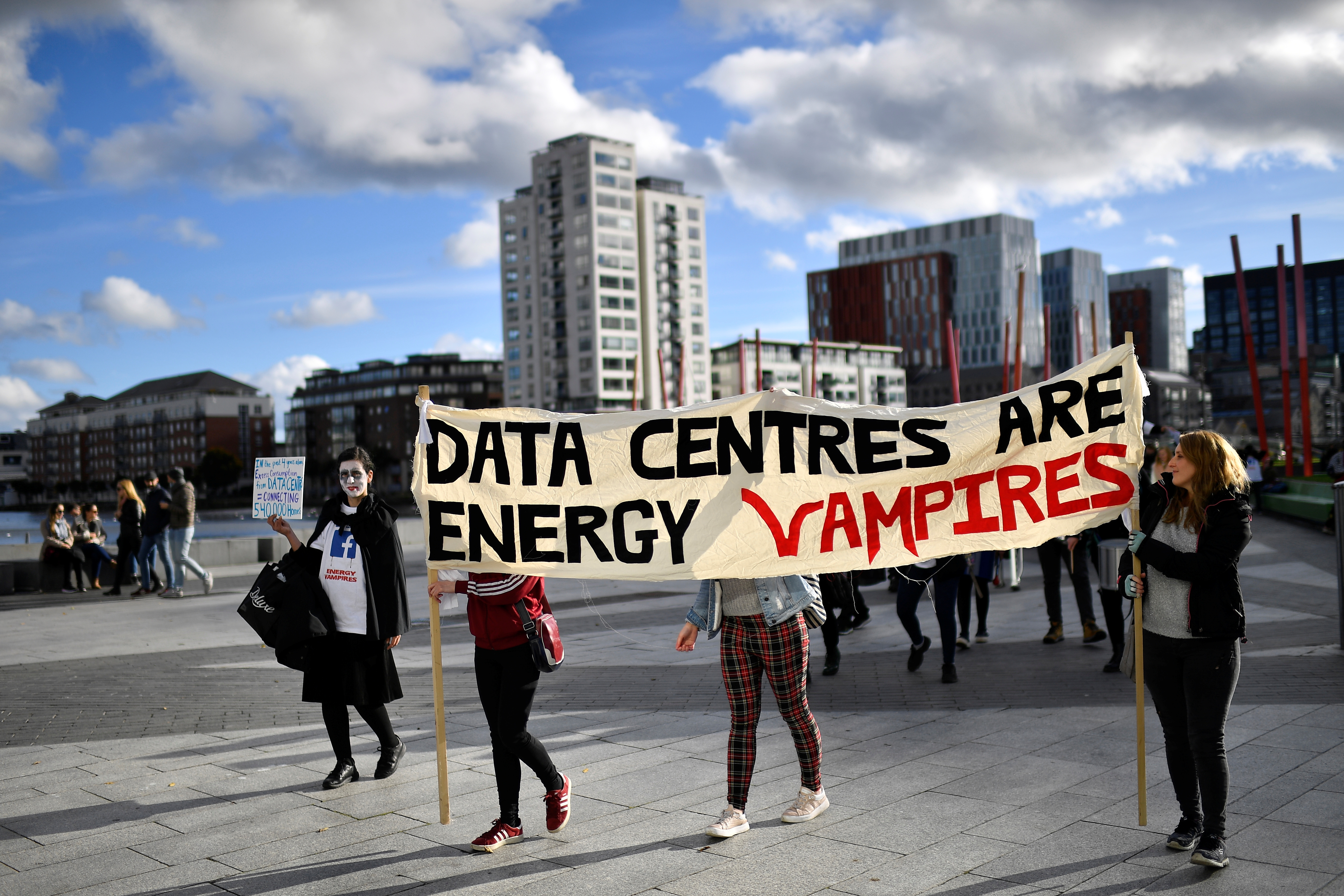 Demonstrators protest outside the European headquarters of Facebook, holding a banner that reads "DATA CENTRES ARE ENERGY VAMPIRES."