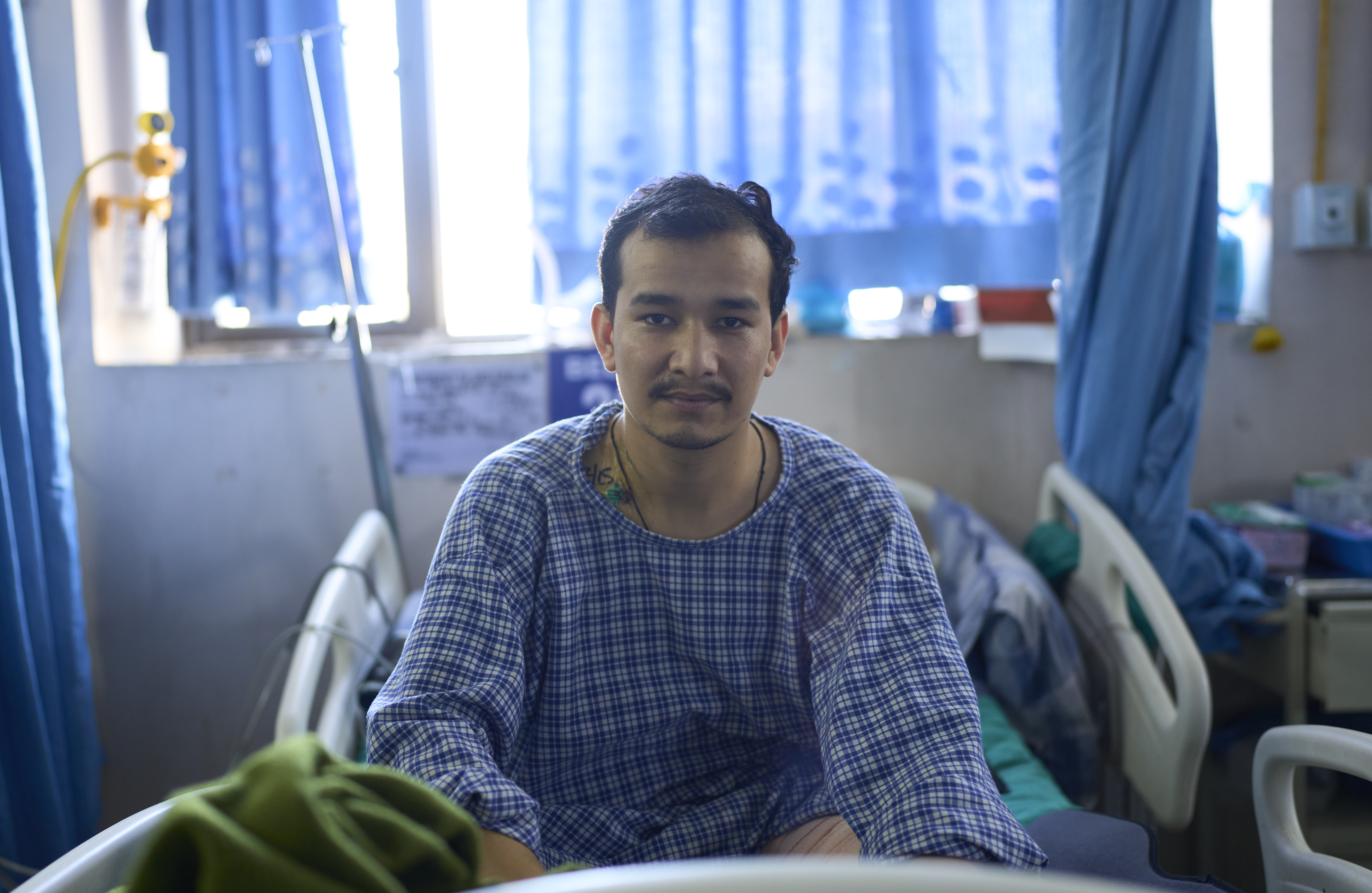 Prakash Bohora, 28, sits on a hospital bed in Kathmandu, Nepal, during treatment after being injured during the Gen-Z protest.
