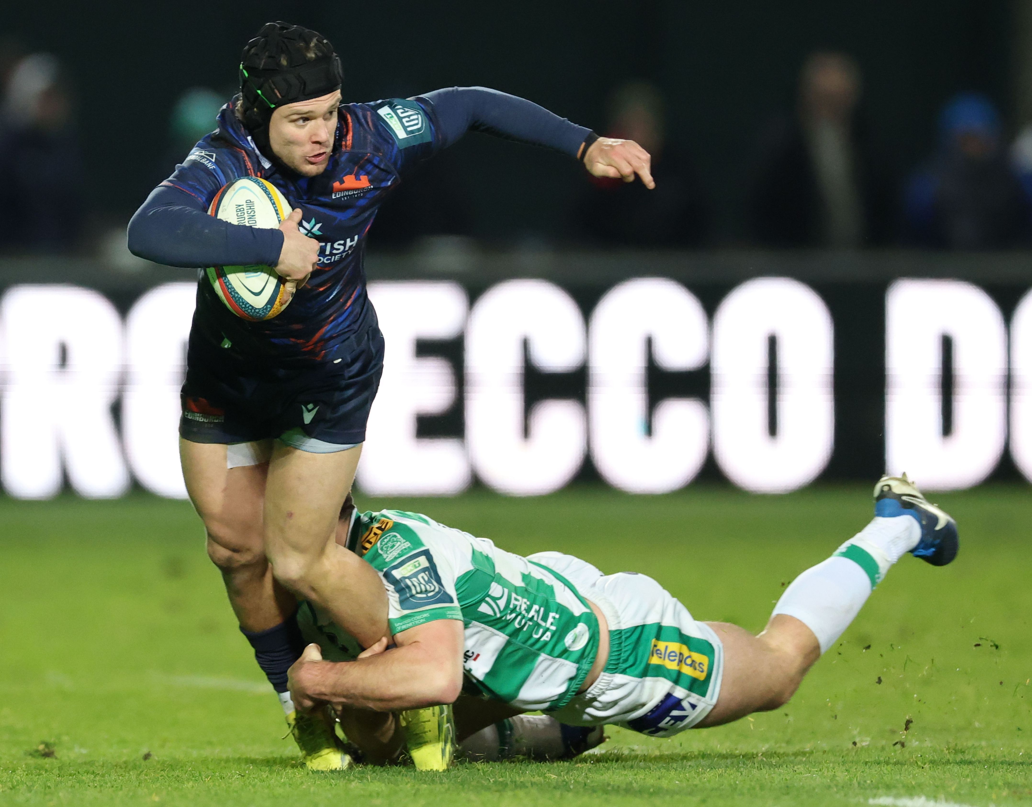Darcy Graham of Edinburgh is tackled by Benetton's Matt Gallagher during a rugby match.