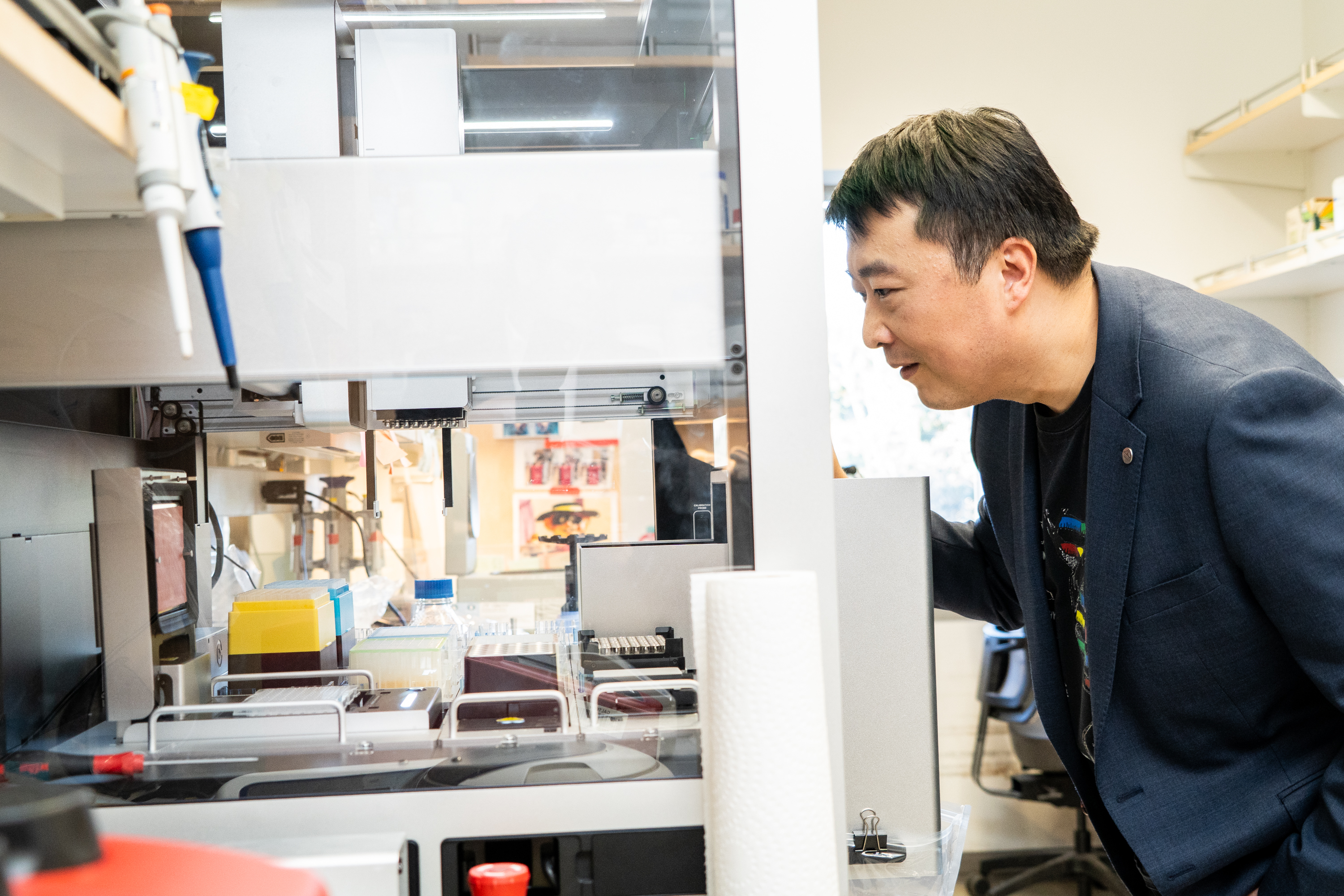 Kaihang Wang demonstrates writing genetic codes in a lab at Cal Tech.