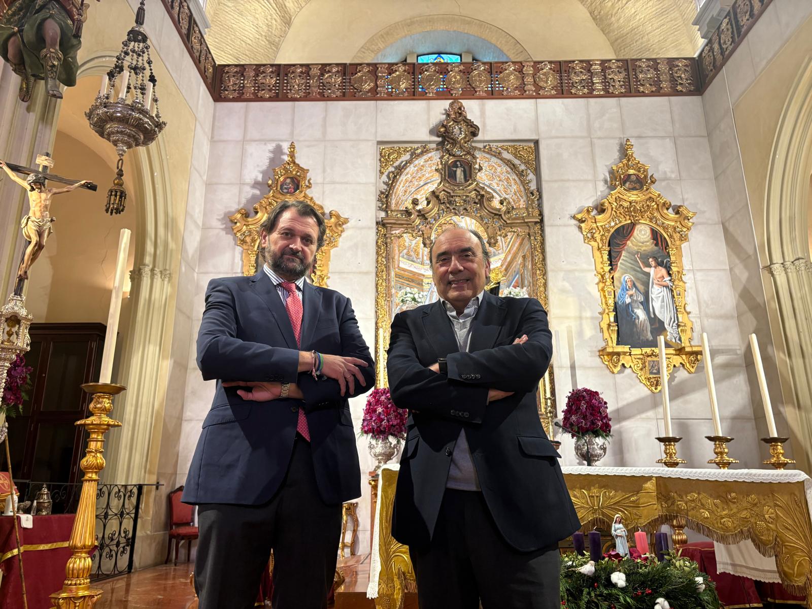 Jose Maria and Jacobo standing in a church in front of statues.