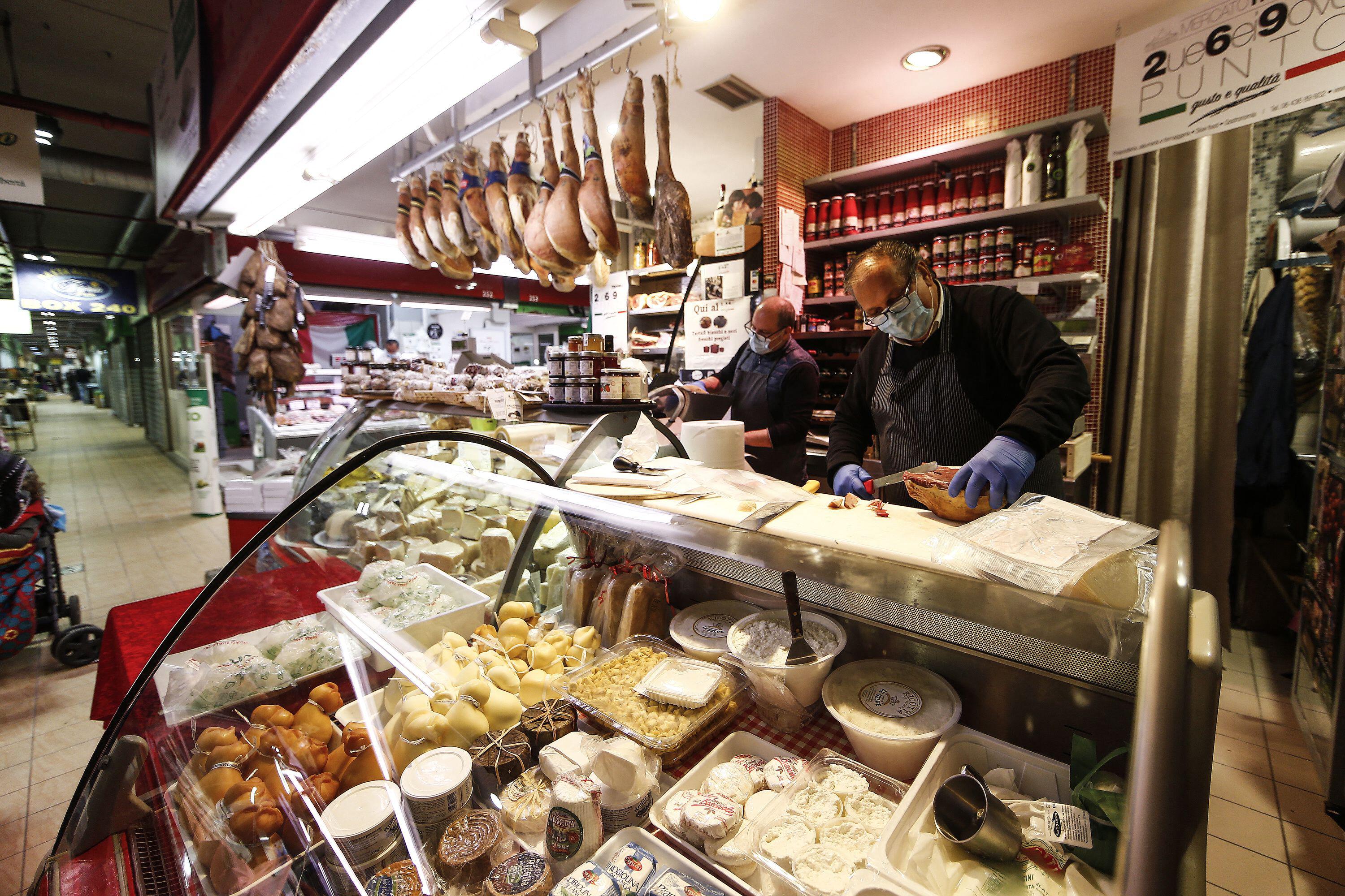 Merchants wearing masks and gloves serve food at the Trionfale market in Rome during the COVID-19 lockdown.