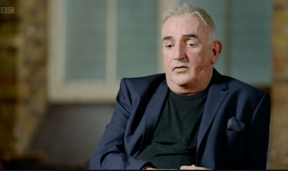 Private detective Gavin Burrows wearing a dark suit jacket and black t-shirt.