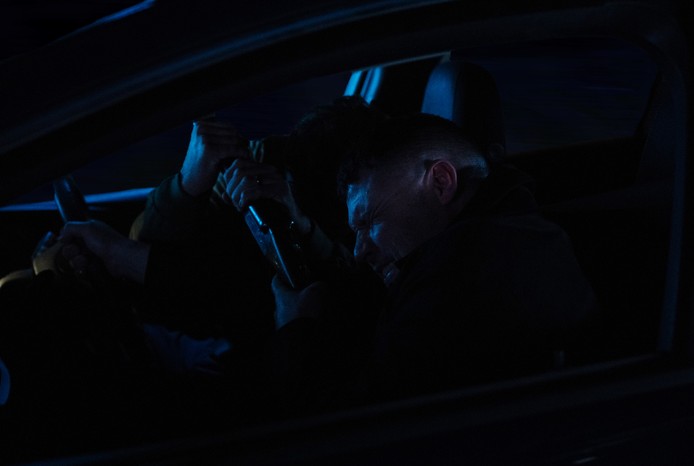 Aaron tries to wrestle the gun off John in a darkened car in a scene from Emmerdale
