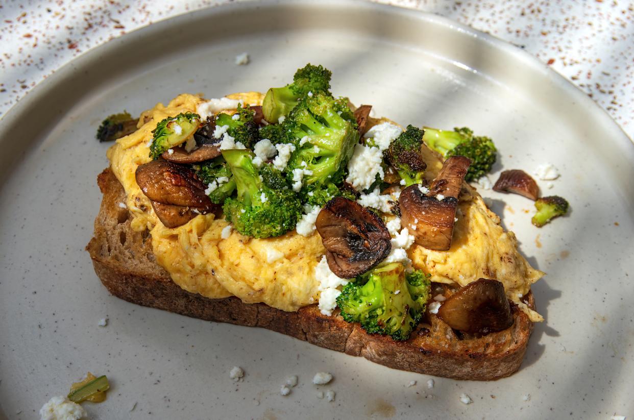 Plate of tostada de la huerta (scrambled eggs,feta cheese, mushrooms and broccoli on toasted sourdough bread)