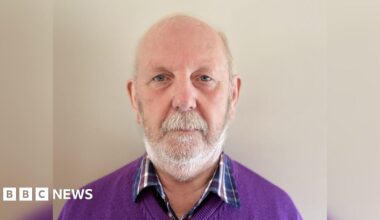 A police Land Rover drives past a security hut