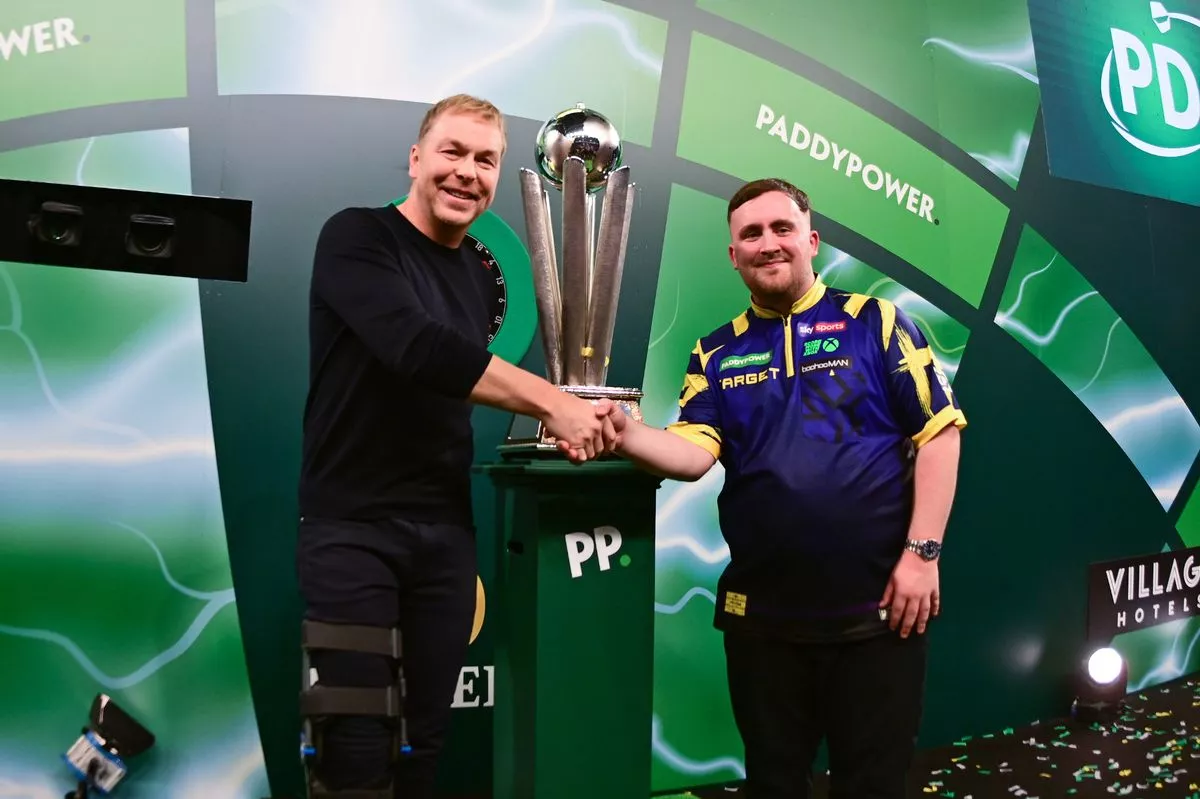 Luke Littler shakes hands with Sir Chris Hoy during the 2025/26 Paddy Power World Darts Championships final at Alexandra Palace, London