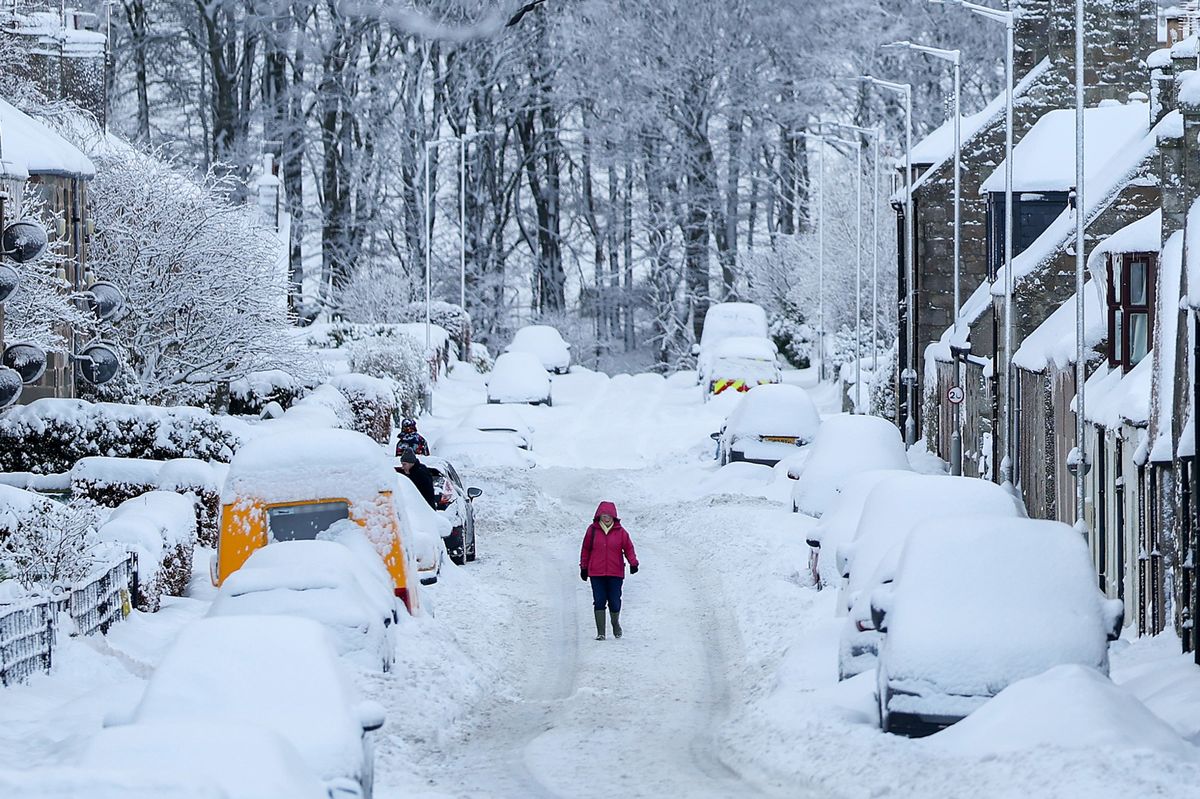 HUNTLY, SCOTLAND - JANUARY 05: People make their way through street following snowfall on January 05, 2026 in Huntly, United Kingdom. The Met Office has given a weather warning of disruption to travel as many people return to work and school following the Christmas break. (Photo by Jeff J Mitchell/Getty Images)