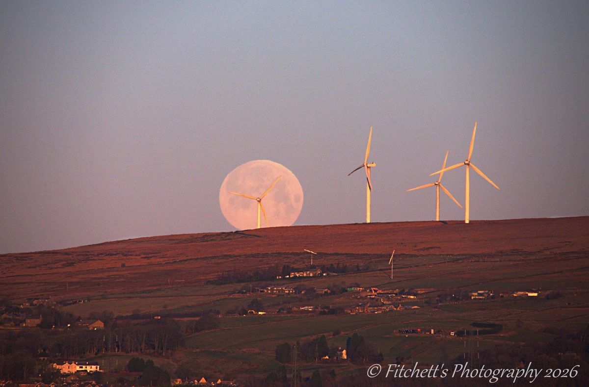The setting Wolf Moon over Scout Moor, Rochdale, on a freezing morning, from the bridge above the A627M.