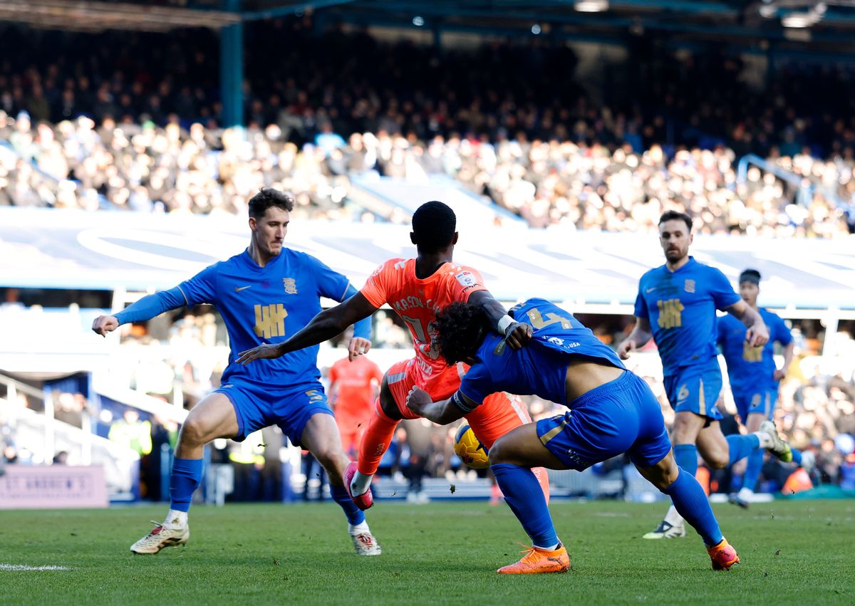 Coventry City's Ephron Mason-Clark (centre) is man-handled by Birmingham City's Tomoki Iwata (right)