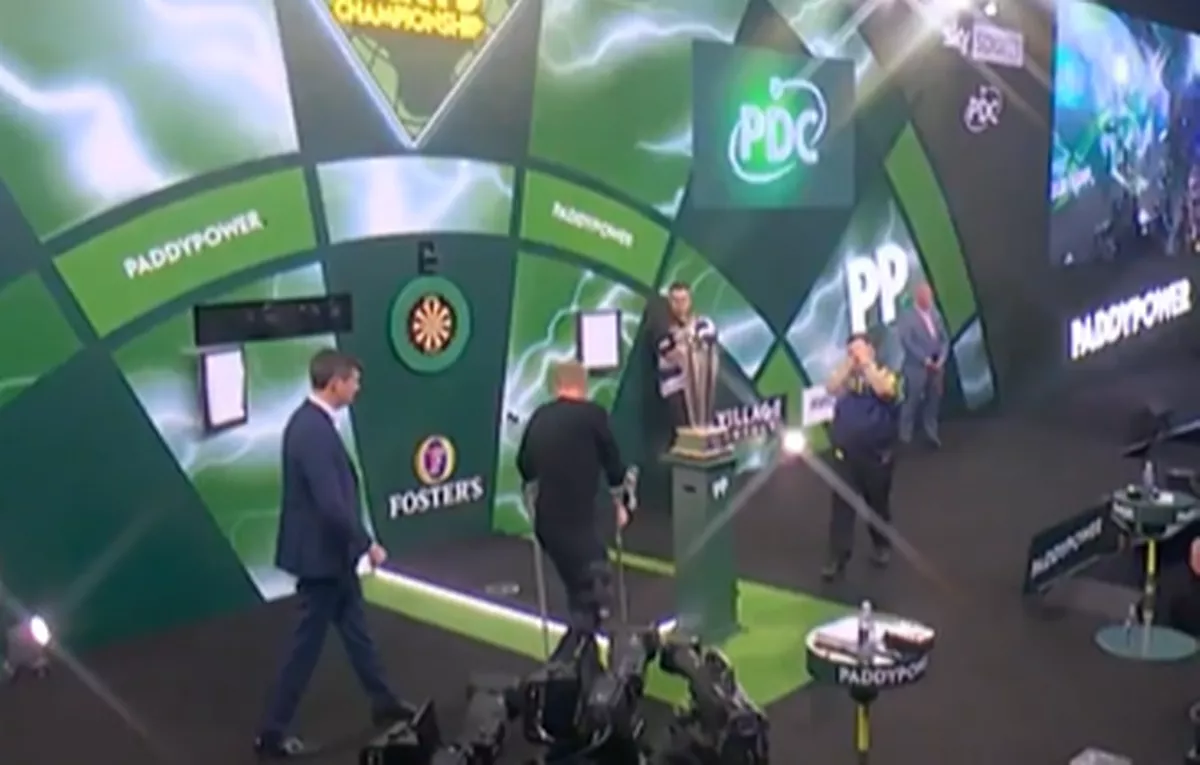 Sir Chris Hoy walking onto the stage on crutches to present the trophy 