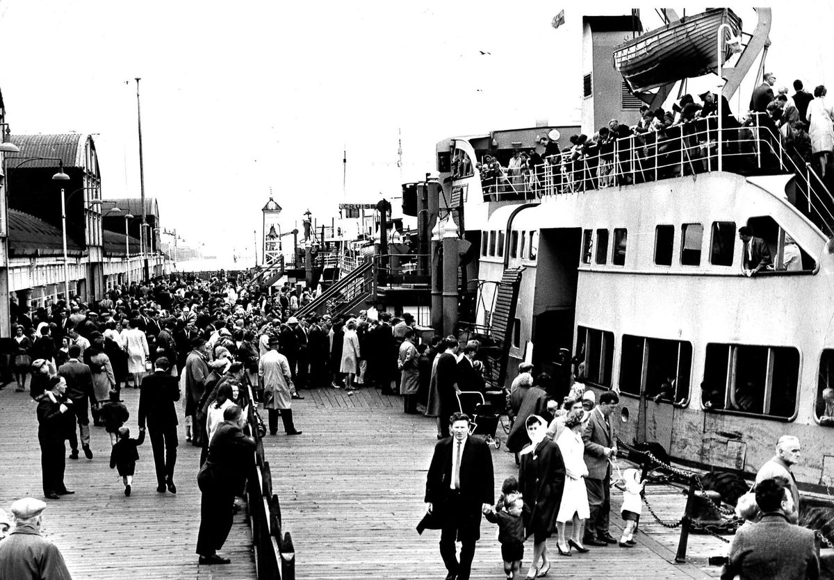 A black and white photo of a busy 1960s scene at the landing stage in Liverpool as the Royal Iris prepares for another cross-river trip.