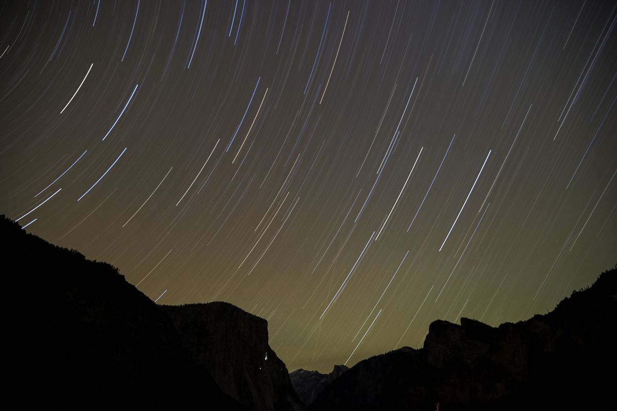 A view shows the Geminids meteor shower streaking across the night sky as stargazers gather at the Valley View of Yosemite National Park in California, United States, on December 14, 2025.