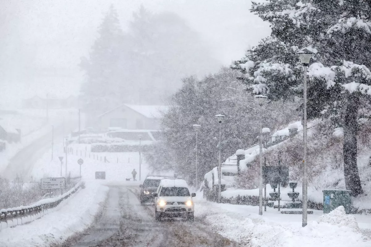 LAIRG, SCOTLAND - JANUARY 18: Cars make their way through snow as the met office issued weather alerts for snow as low temperatures continue across the north of the country on January 18, 2024 in Lairg, Scotland.