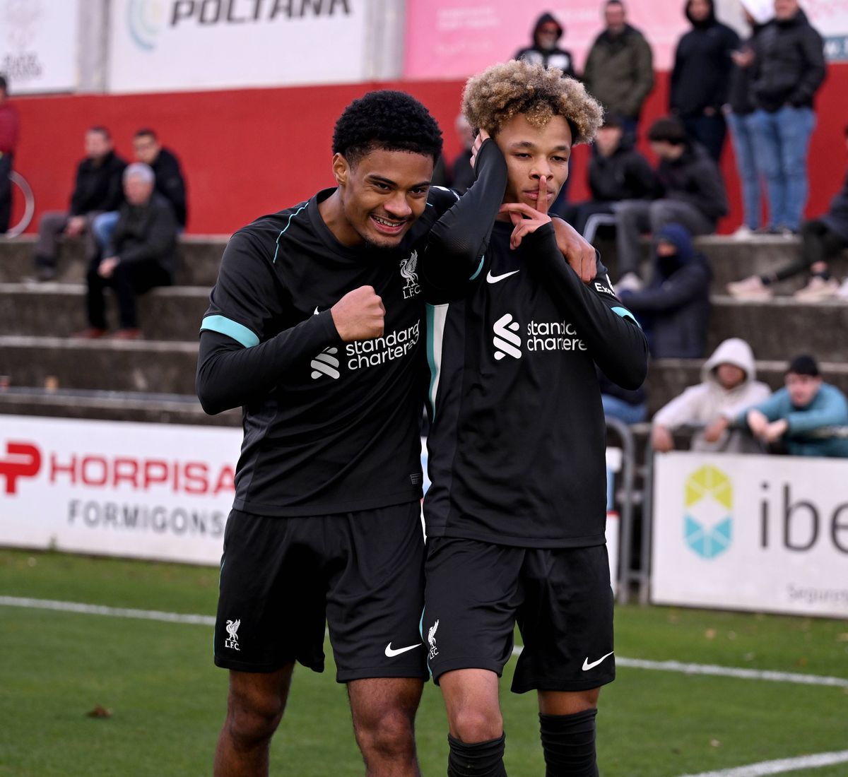 Trent Kone-Doherty of Liverpool celebrates with Kyle Kelly after scoring his team's second goal during the UEFA Youth League match at Girona on December 10 2024