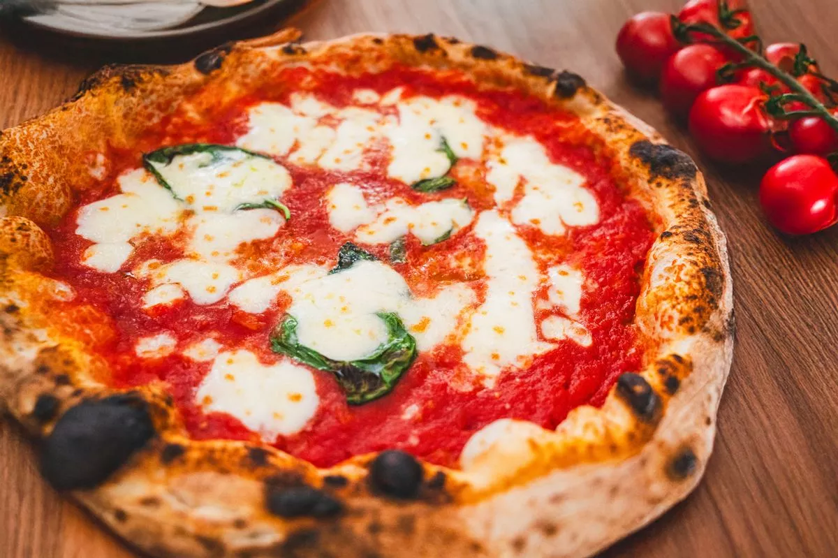 Neapolitan pizza Margherita with fresh tomatoes and basil, a classic Italian dish.