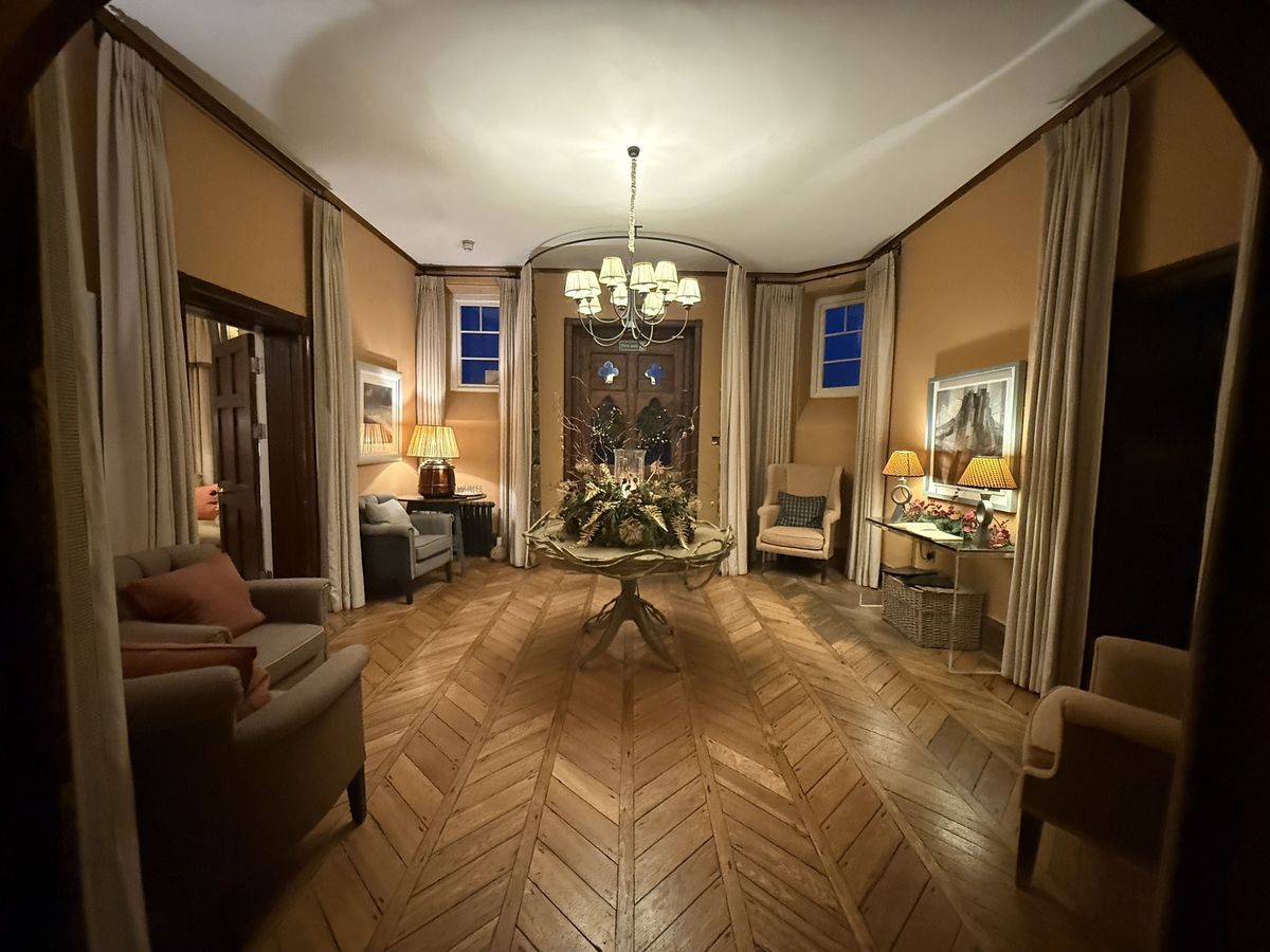 Grand yet very warm and welcoming entrance hall Grove of Narberth award-winning country hotel including wooden floor and central floral display