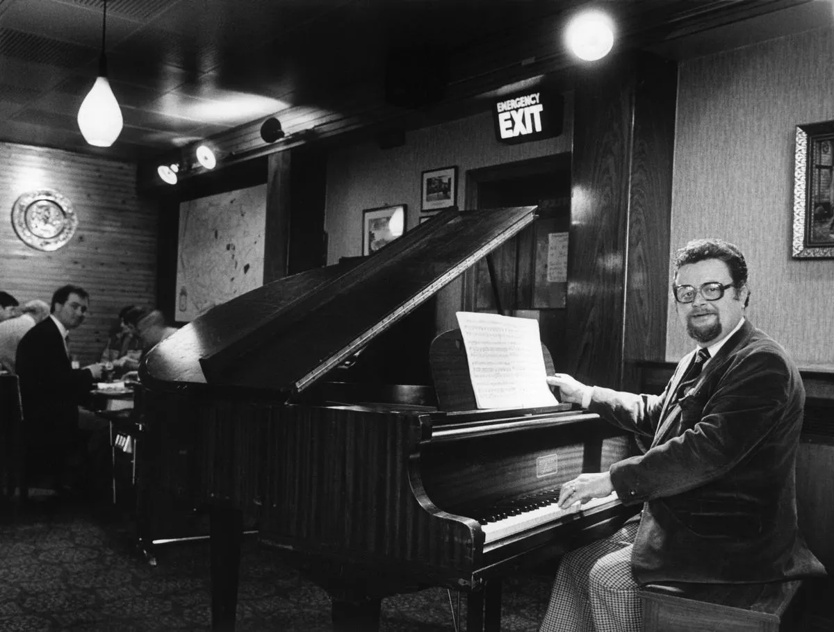 Pianist Mike Leroy at the grand piano in the ballroom at the Mons Hotel in Bootle, Merseyside. February 1985.