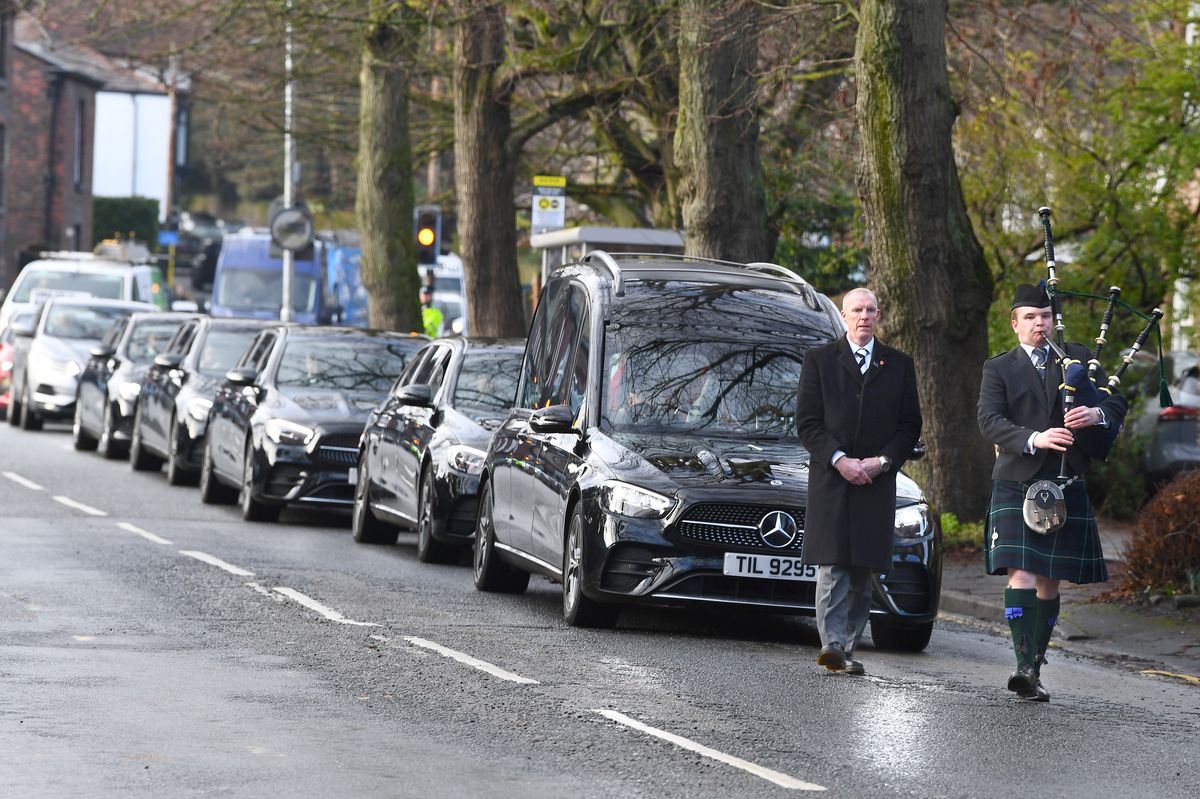 A Piper from Liverpool Scottish leads the funeral cortege of John Courtney through Gateacre Village.