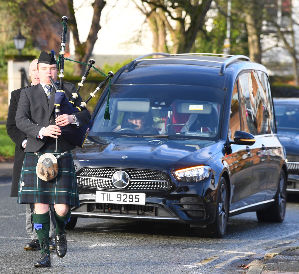 A Piper from Liverpool Scottish leads the funeral cortege of John Courtney through Gateacre Village.(