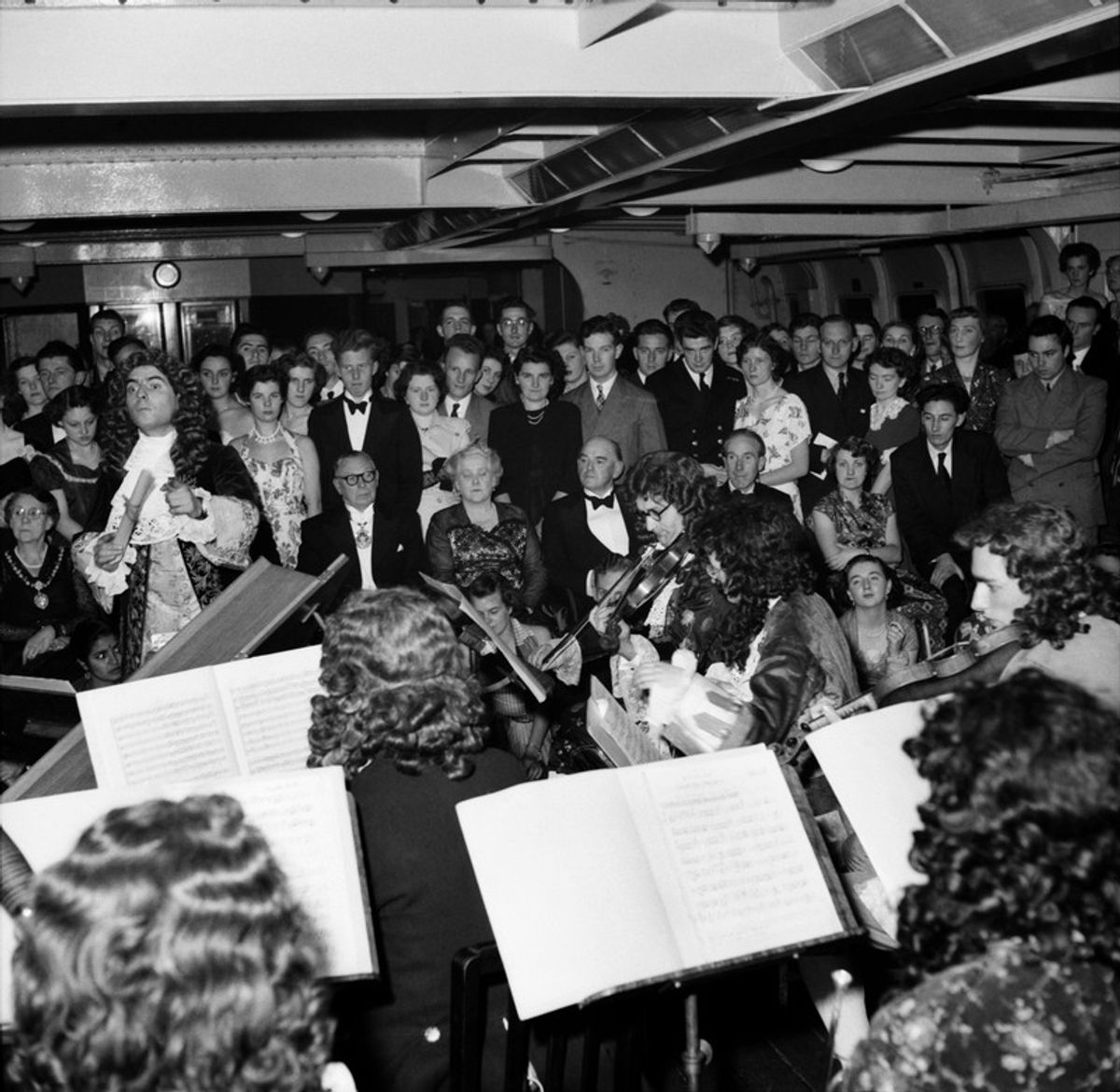 Black and white photo of classical musicians performing about the Royal Iris ferry. Liverpool chamber music group in 18th Century costume aboard the Royal Iris in September 1952.
