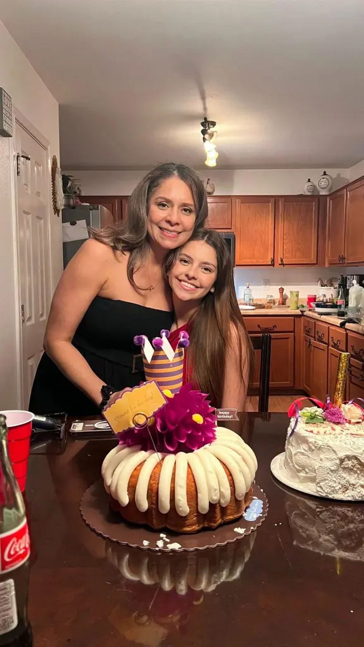 Camila is pictured with a family member at home