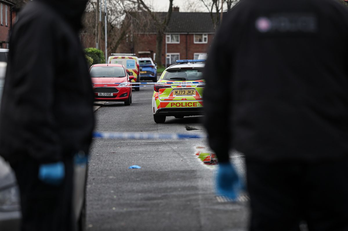 Police and forensic teams attend the scene of a fatal New Years Eve stabbing in Bury