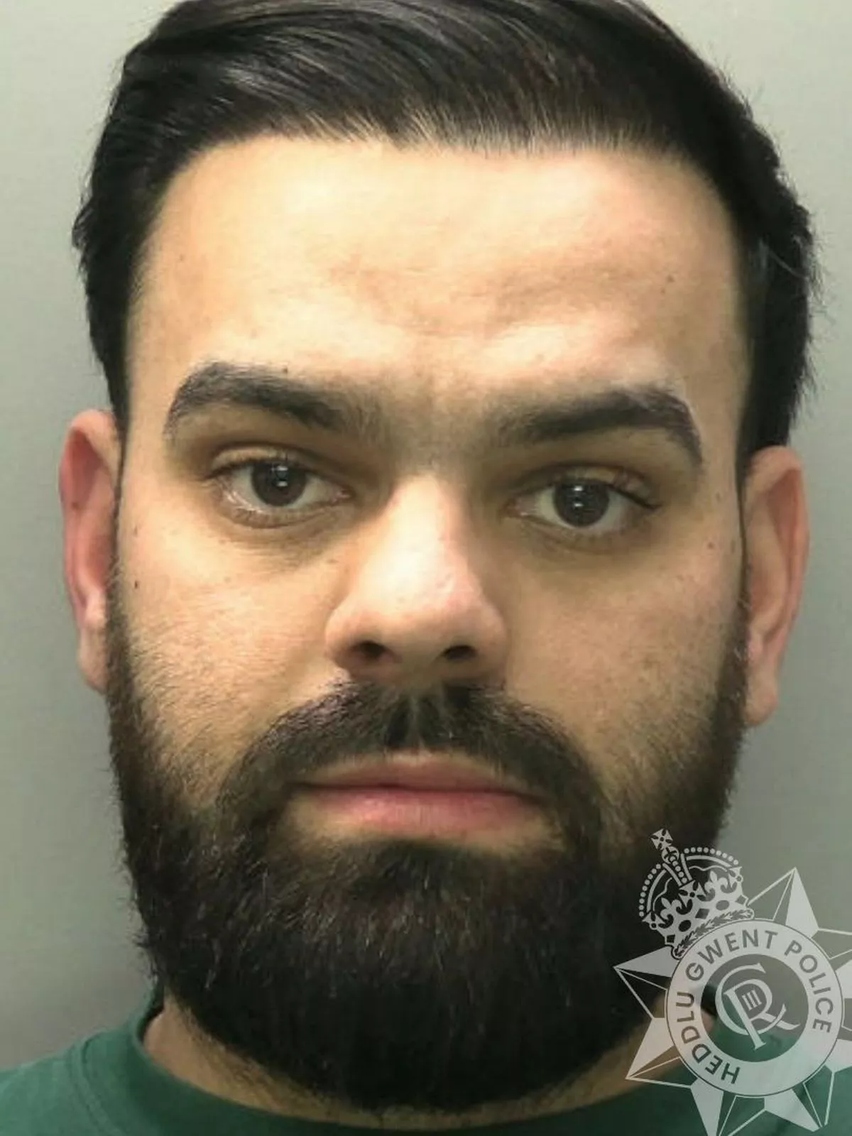 Custody photo of Vasile Vasile, 25, who pressured a man to pay him £1,300 in exchange for mobile phones which were fakes and of poor quality.