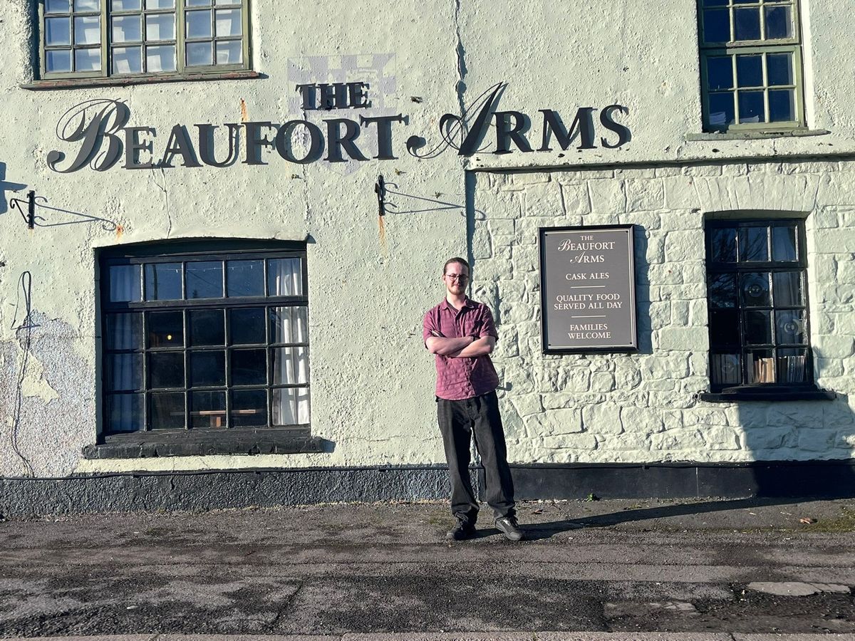 A landlord stood outside his pub