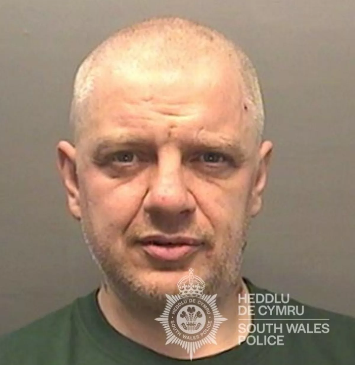 Custody image of Michael Mathews, a white man in his mid-50s with a shaved head