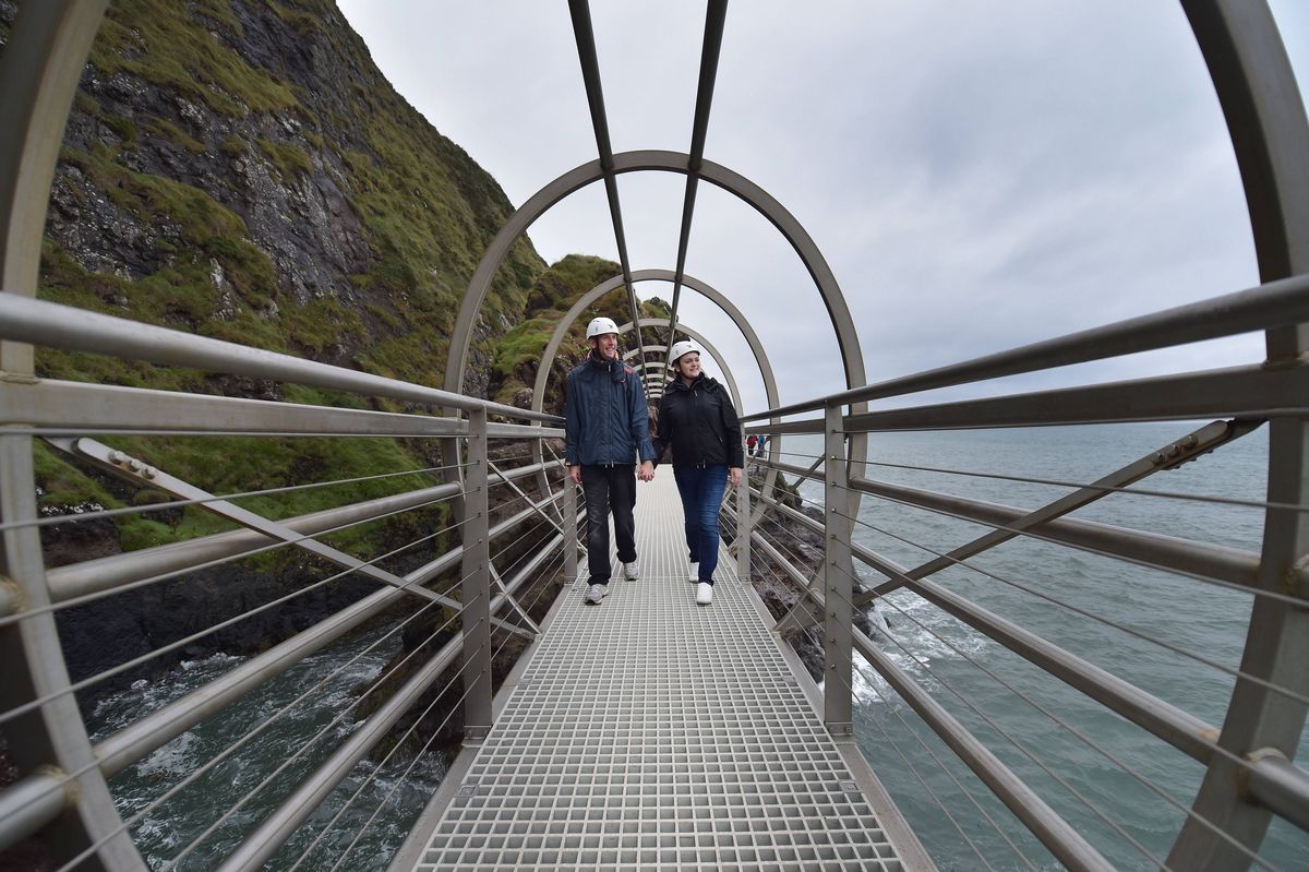 ANTRIM, NORTHERN IRELAND - AUGUST 19:  Tourists make their way along The Gobbins coastal path on August 19, 2015 in Antrim, Northern Ireland. The Islandmagee cliff path walk has reopened after six decades of closure and a £7.5 million investment. Comprimising of suspension tubular bridges, caves, steps and tunnels carved through the north Antrim coastline the trail was once a thriving 1900's hotspot for walkers and thrill-seekers. Designed by Irish railway engineer Berkley Deane Wise and opened in 1902 to Edwardian era visitors the path comes with a health warning for those weak of heart or suffering from a general lack of fitness due to it's steep incline.  (Photo by Charles McQuillan/Getty Images)