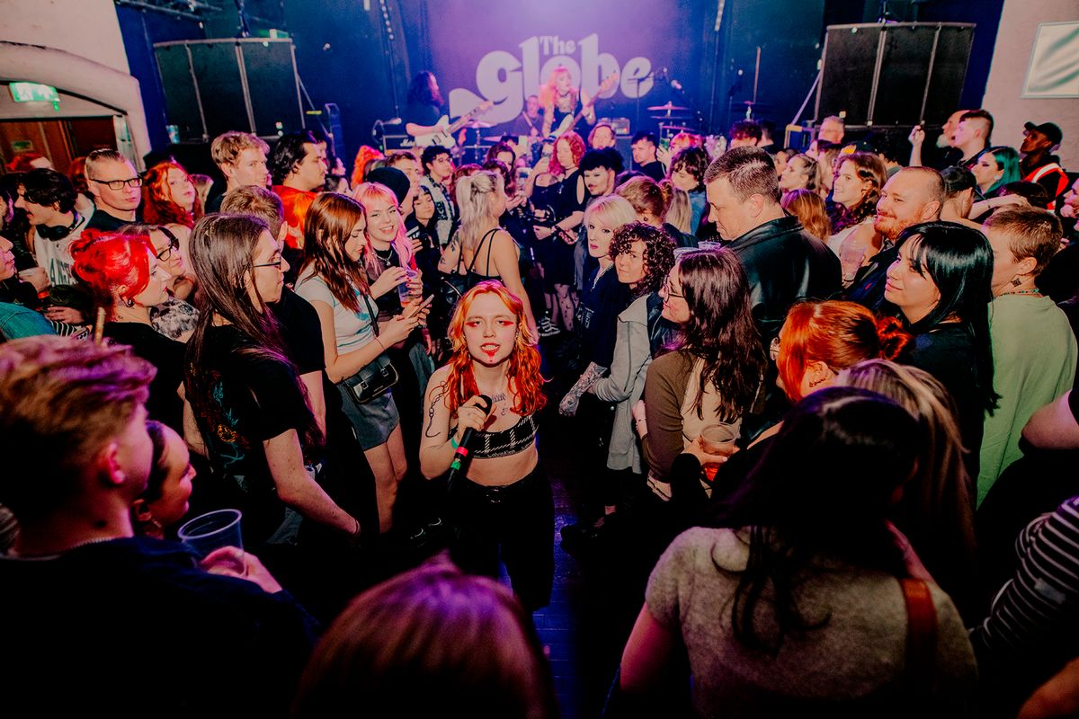 A woman singing in the middle of a busy crowd
