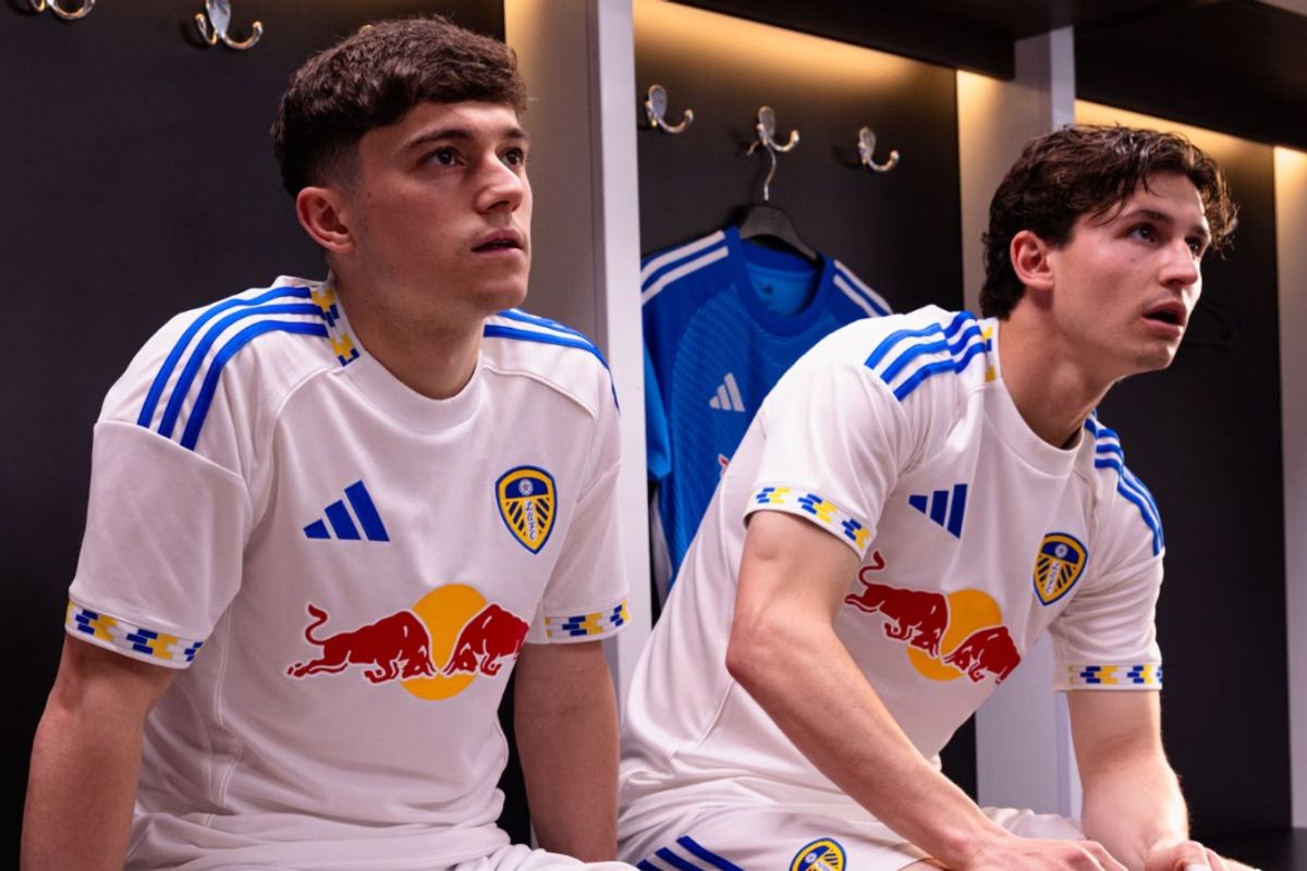 Two Leeds United players sat down wearing the club's 2025/26 home shirt