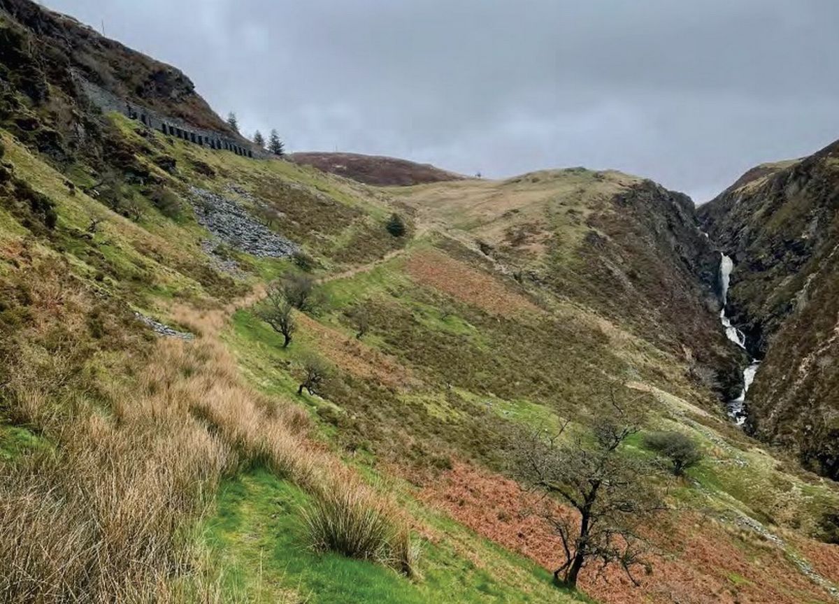 View east through Cwm Cynfal showing the waterfall right and the B4407 left .