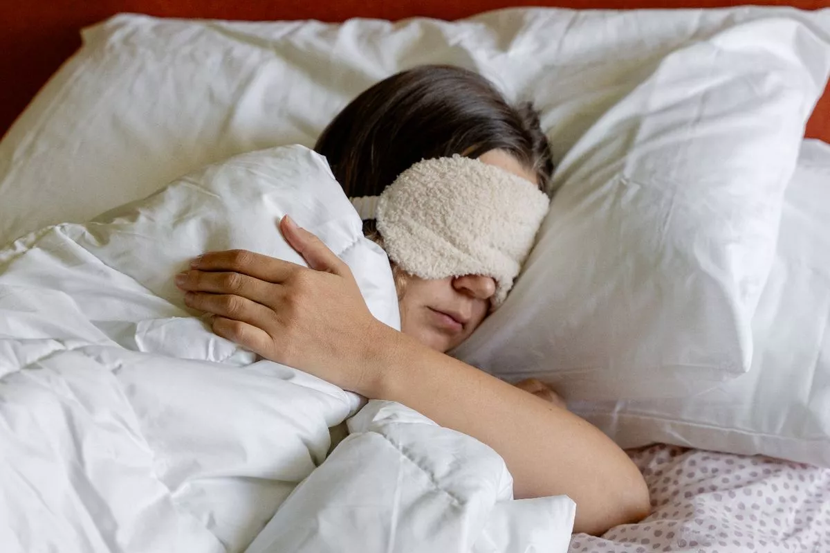 a woman sleeping with a Eye Sleeping Mask on her head