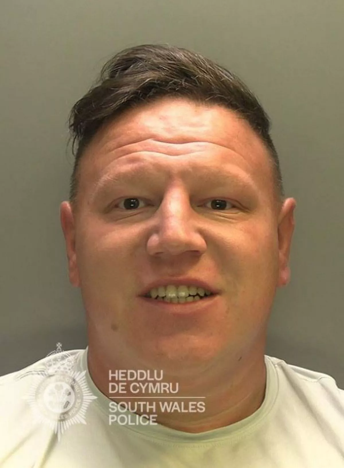 A man smiling in a mug shot