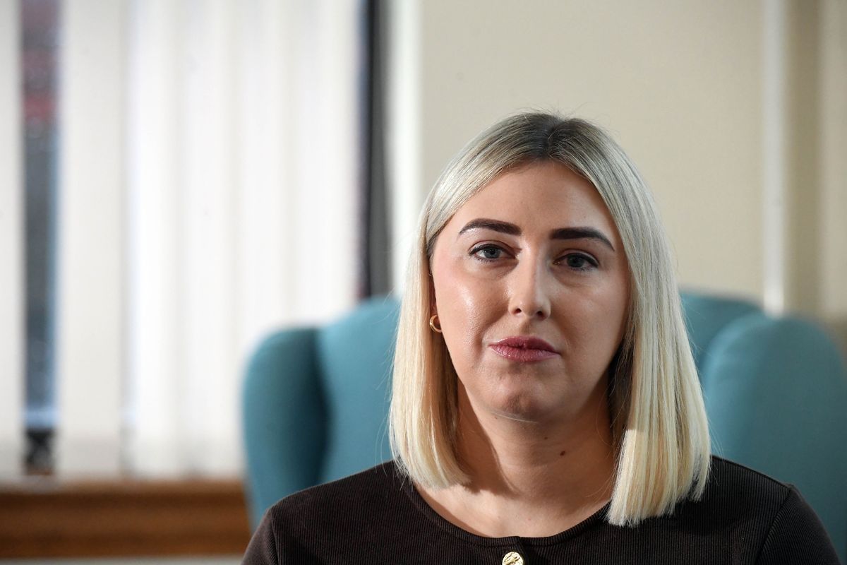 A young blonde woman in a brown top