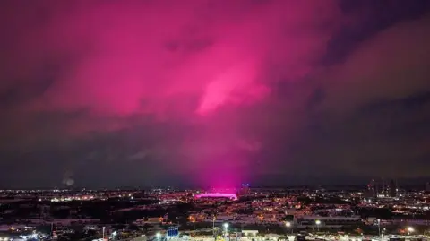 Getty Images An aerial shot of Birmingham city centre which shows a vivid pink glow, coming from the St Andrew's football ground, being reflected off clouds above it, sending the whole sky pink
