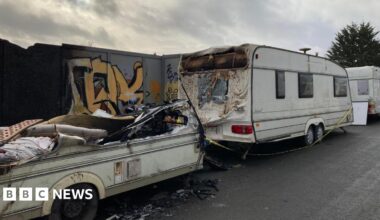 Prime Minister Mark Carney, wearing a black suit jacket, and a white button-up shirt leans his chin on his hands. He has short grey and black hair and is looking away from the camera.