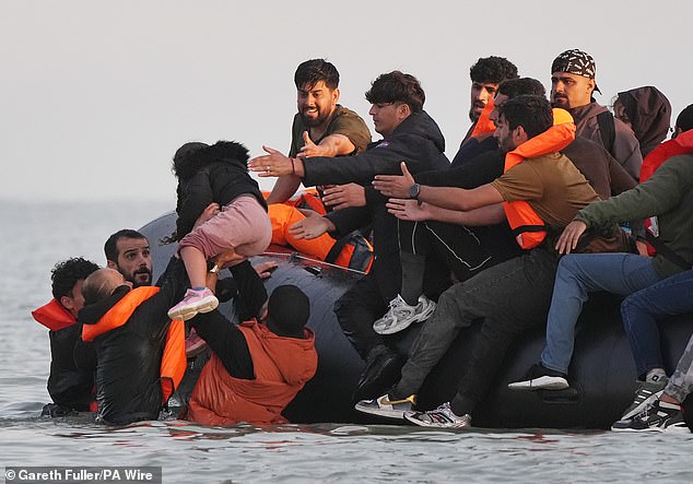 Migrants in France clambering into a small boat bound for Britain in July last year