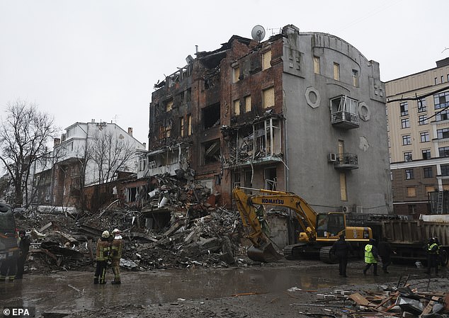Rescuers work to find bodies amongst the rubble of an apartment block in Kharkiv, Ukraine, on January 3