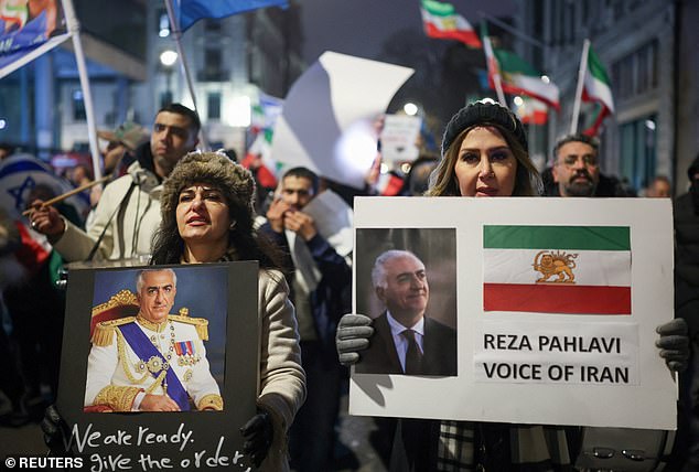 Protesters in London on Sunday hold placards carrying the image of exiled crown prince Reza Pahlavi, who fled to the US with his father, the deposed Shah, after the Islamic Revolution in 1979