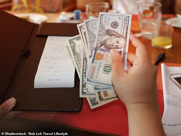 As an increasing number of restaurants across the U.S. add a credit card surcharge - often around four per cent - onto bills, a travel expert has advised travellers to instead use cash (File image)