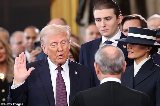President-elect Donald Trump takes the oath of office as Barron Trump and Melania Trump look on during his second inauguration last year