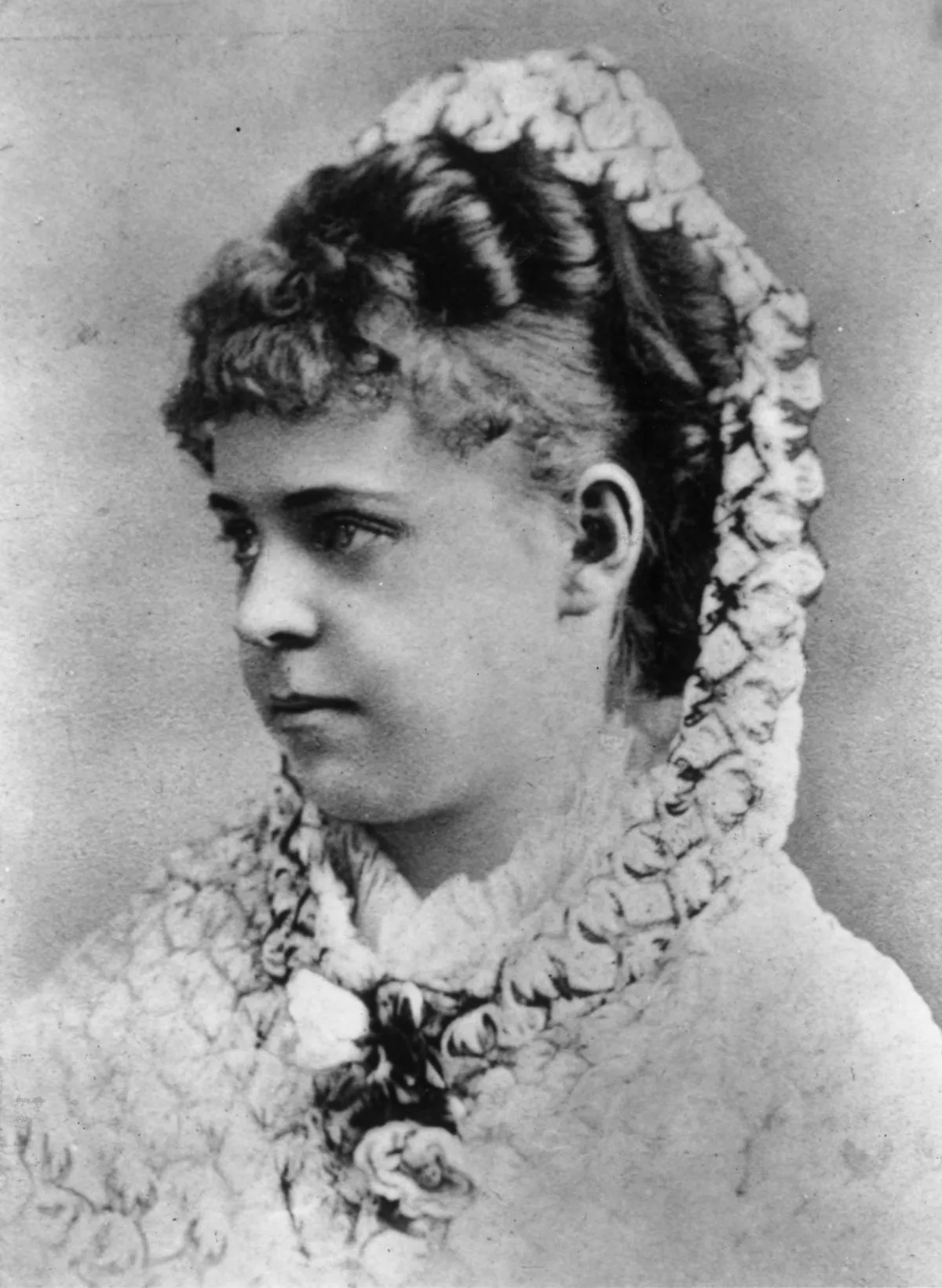 Profile photograph in black and white of a young woman, her hair plaited and tied in a shawl.